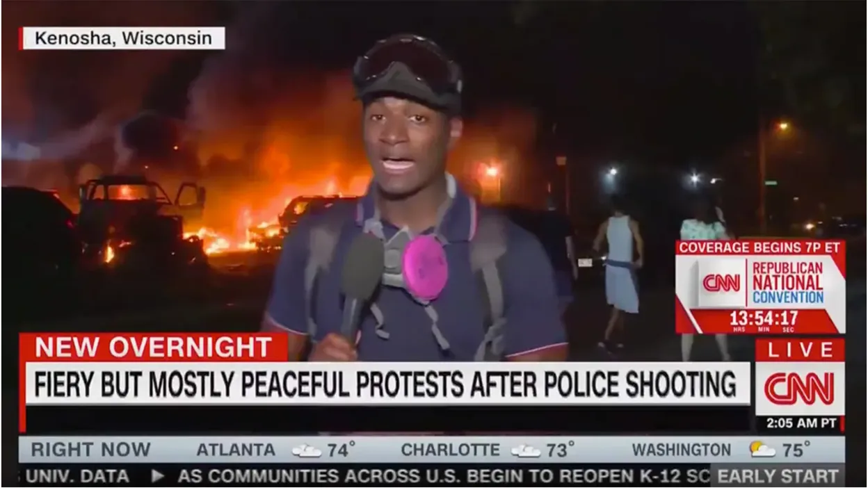 CNN 記者站在火光熊熊的現場進行報導，螢幕底部的字幕寫著：「警方槍擊後，激烈但基本和平的抗議。」但其時距離佛洛伊德事件已經有三個月。（網路截圖）