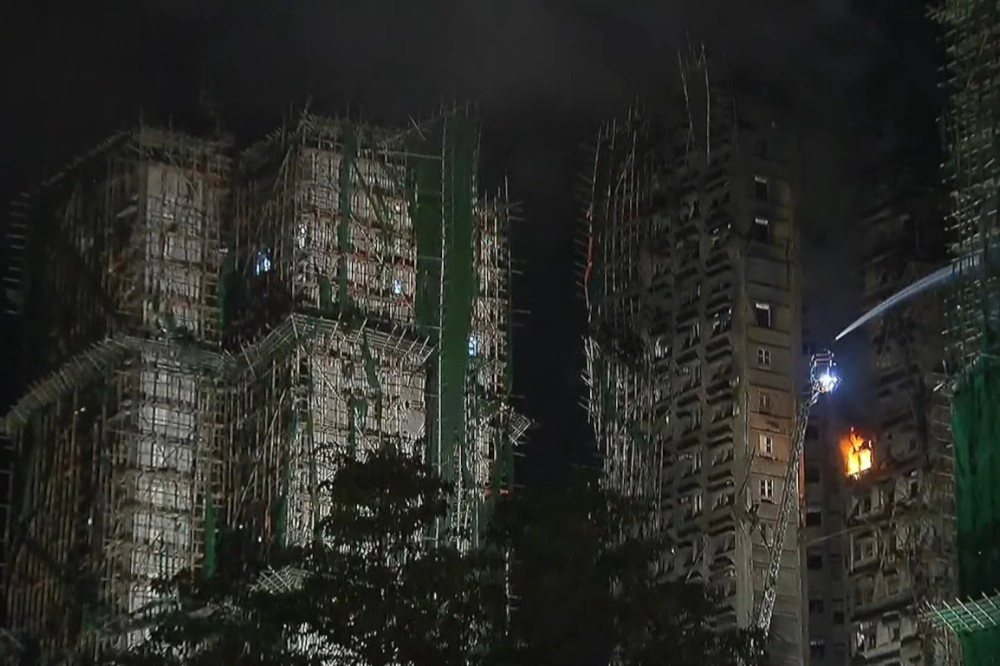 宏福苑大部火勢已得到控制，但28日清晨仍有火光竄出。（截自現場直播畫面）