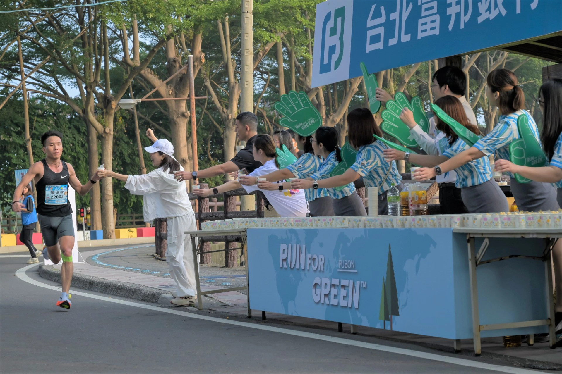 富邦企業志工於田中馬拉松賽事補給站為選手加油,推動運動風氣並響應綠色永續的理念。(富邦金控提供)