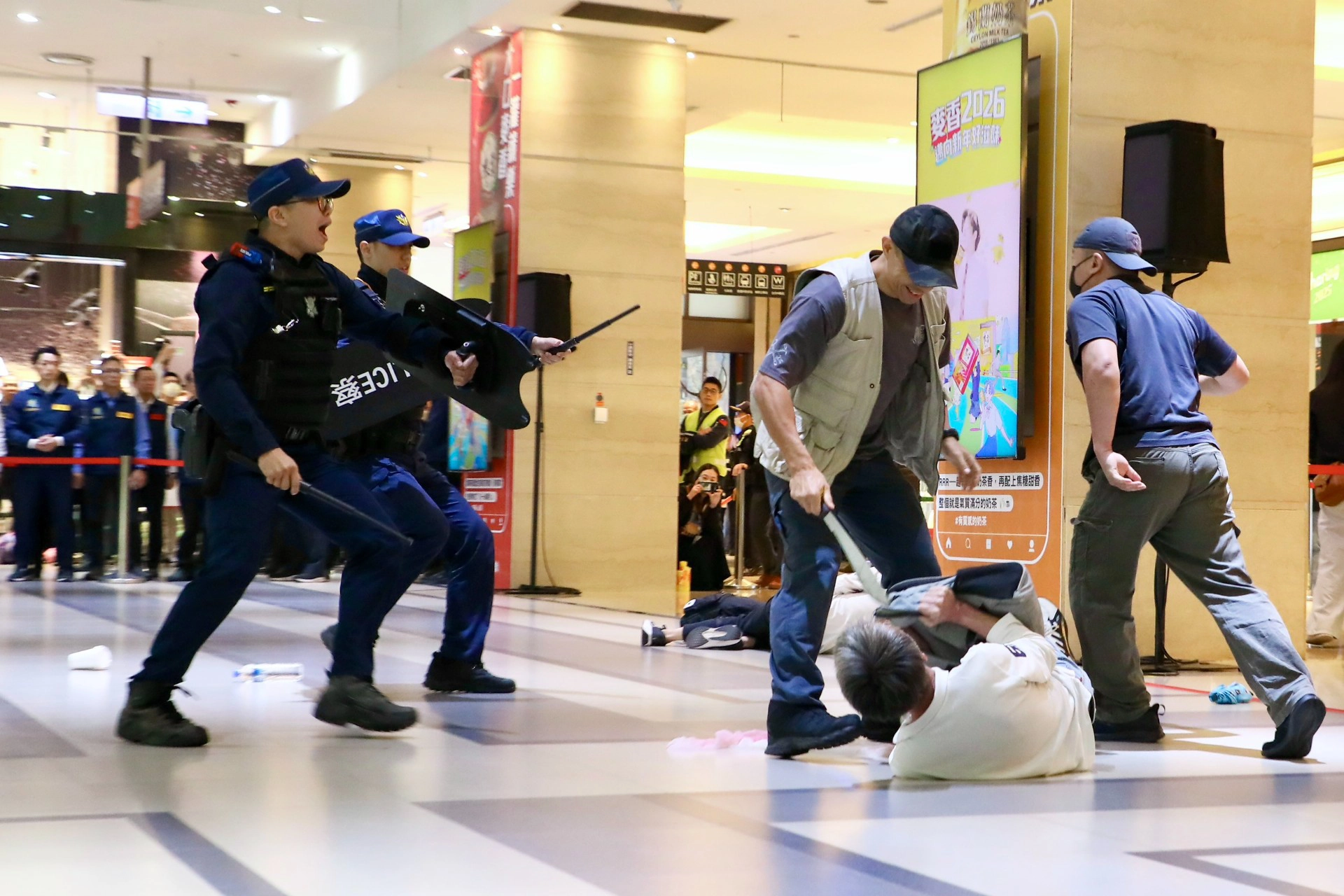 演練模擬歹徒持長刀攻擊民眾。（王侑聖攝）