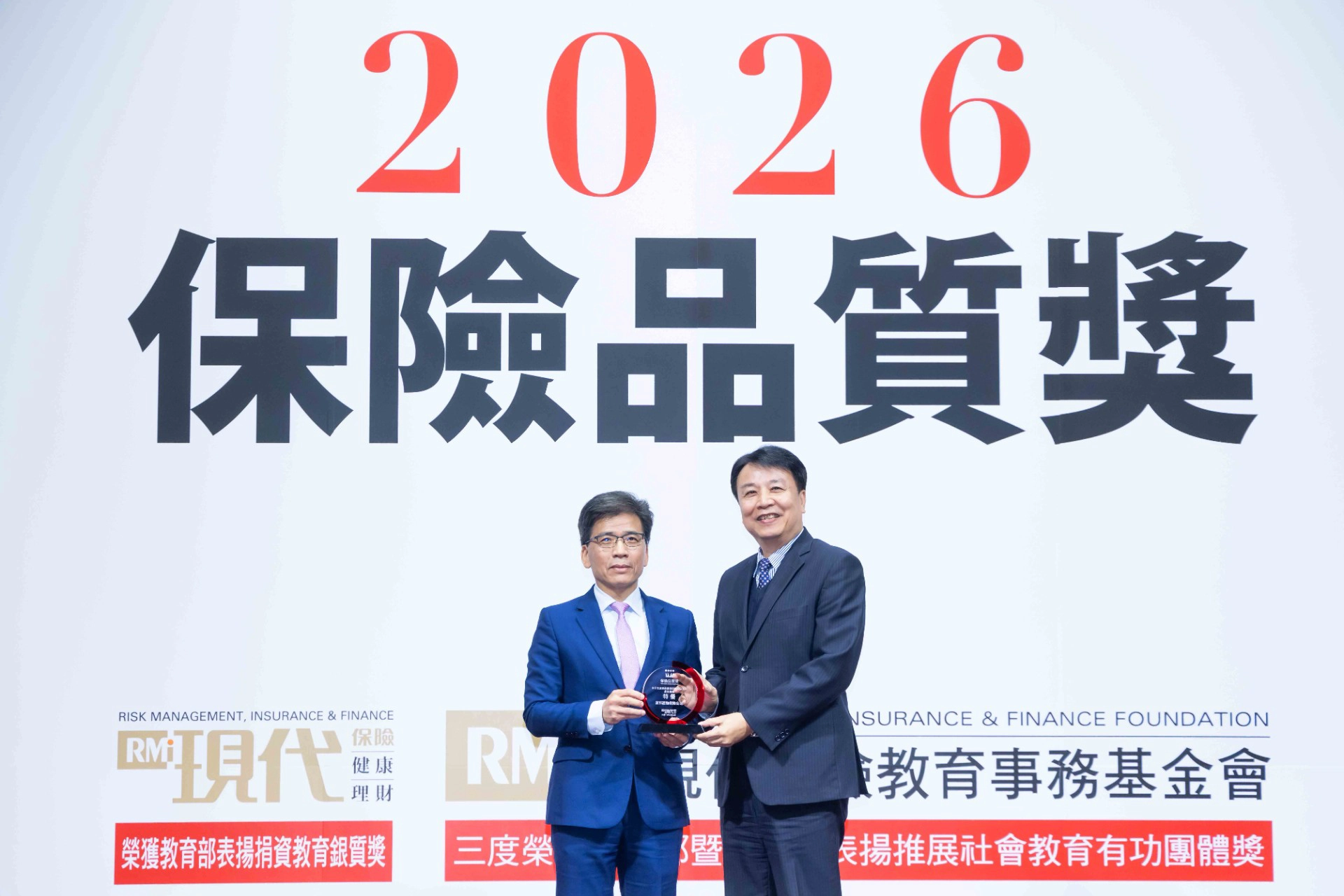 《現代保險雜誌》「2026保險品質獎」，富邦產險獲「最佳形象」、「最佳專業」、「最佳售後服務」及「最值得推薦」四項特優，由金管會彭金隆主委頒發獎項予富邦產險賴榮崇總經理(右)。(富邦金控提供)