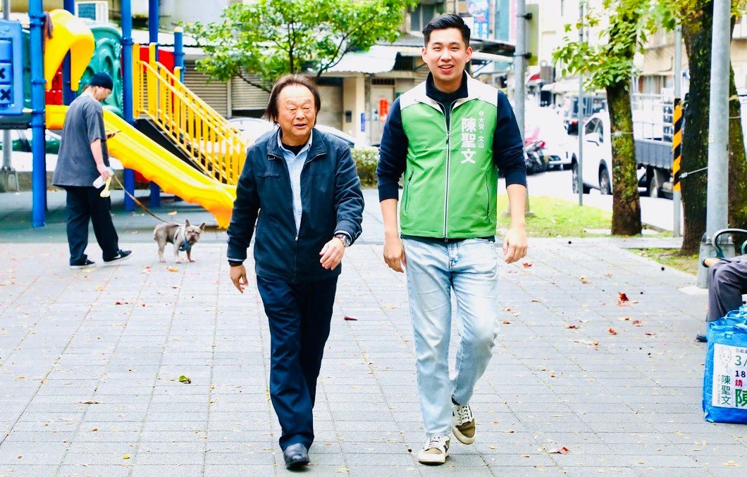 王世堅與陳聖文一同走訪社區、與鄉親交流互動，展現師徒並肩深耕大安文山基層的畫面。（王侑聖攝）