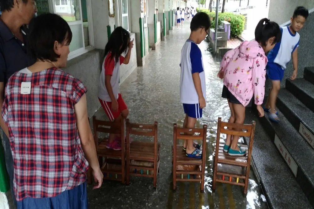 台南國小遇雨淹水　學童踩椅涉水苦中作樂　