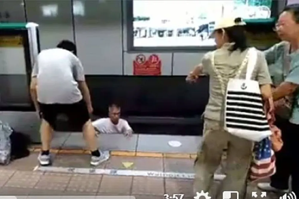 【影片】男子吵架怒跳軌　婦人不滿有人施救不斷踹踢