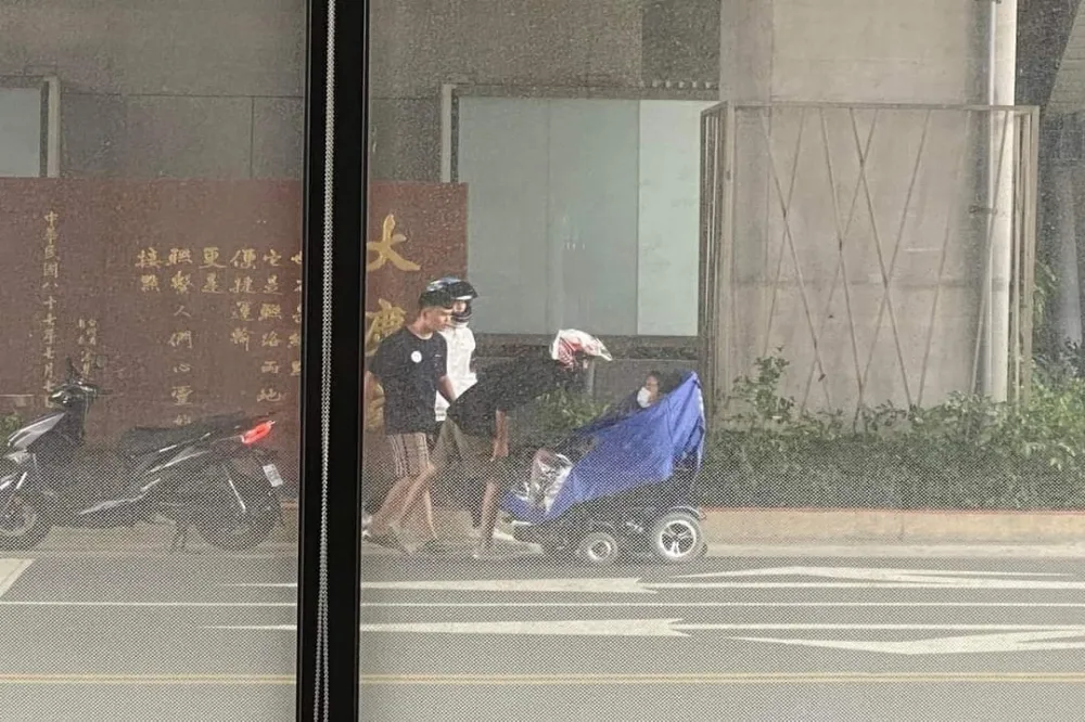 颱風天最暖一幕！身障騎士冒雨騎車渾身濕透　3騎士幫穿雨衣