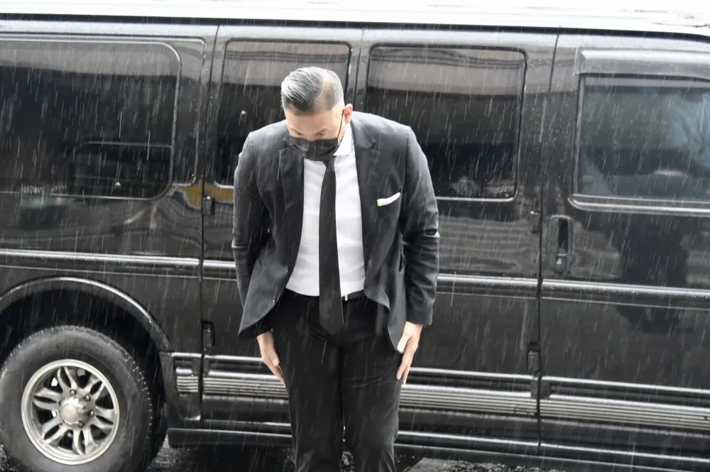 爆性騷後50天首露面　陳建州雨中鞠躬比讚：用法律捍衛自身清白
